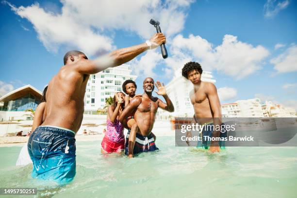 wide shot family taking selfie in  ocean during family vacation - all inclusive holiday stock pictures, royalty-free photos & images