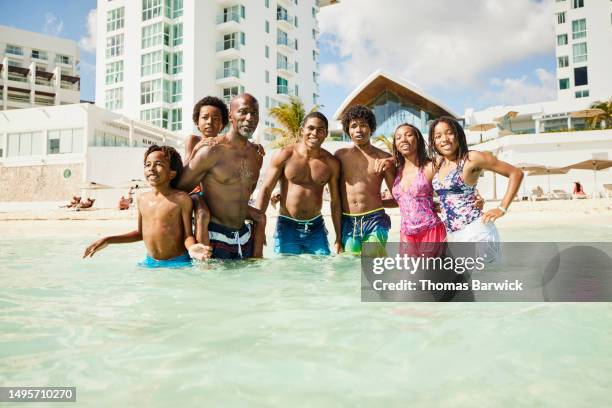 wide shot family playing in tropical ocean during family vacation - all inclusive holiday stock pictures, royalty-free photos & images
