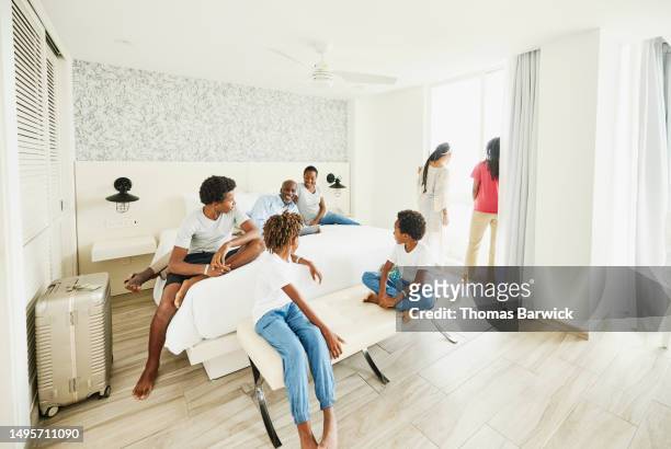 wide shot smiling family relaxing in hotel room at all inclusive resort - all inclusive holiday stock pictures, royalty-free photos & images