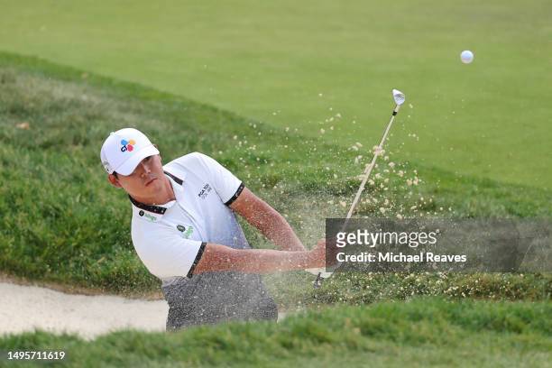 Si Woo Kim of South Korea plays a shot from a bunker on the 16th hole during the third round of the Memorial Tournament presented by Workday at...