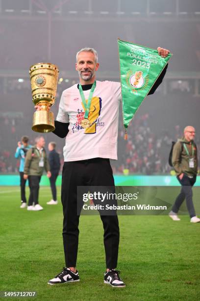 Marco Rose, Head Coach of RB Leipzig, celebrates with the DFB Cup trophy and a match pennant after the DFB Cup final match between RB Leipzig and...