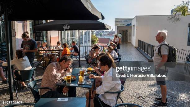 Tourists have lunch at Erdade de Peso restaurant by the Miradouro do Chão do Loureiro in Castelo de Sao Jorge historical neighborhood on June 03,...