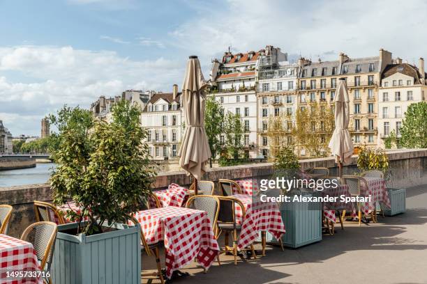 cafe on the bank of seine river on a sunny day, paris, france - bistro paris fotografías e imágenes de stock