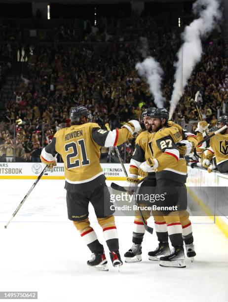 Shea Theodore of the Vegas Golden Knights is congratulated by Brett Howden and Brayden McNabb after scoring a goal against the Florida Panthers...