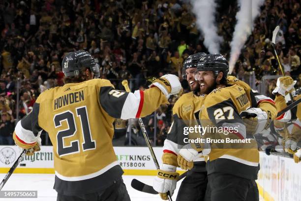 Shea Theodore of the Vegas Golden Knights is congratulated by Brett Howden and Brayden McNabb after scoring a goal against the Florida Panthers...