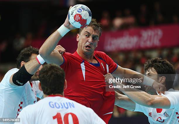 Momir Ilic of Serbia is challenged by Croatia defenders during the Men's Handball Preliminary match between Serbia and Croatia on Day 4 of the London...