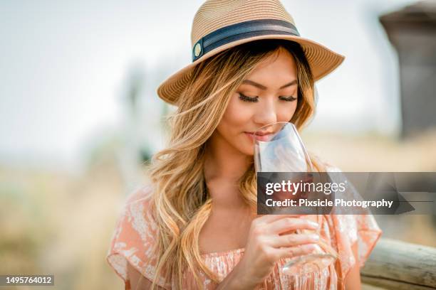 woman outside enjoying a glass of wine - rose wine stock pictures, royalty-free photos & images