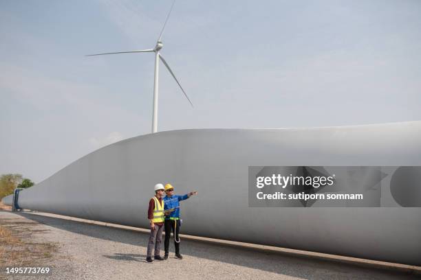 engineer drone technician flying to inspect wind turbine - structure actionnée par le vent photos et images de collection