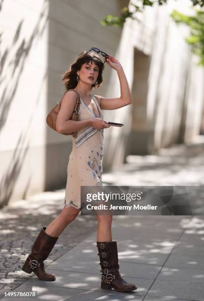 Lea Naumann wearing Miu Miu brown leather Metall boots, Prada beige leather Moon bag, Nisse mini dress with crystal and Pearl details, Acne Studios...