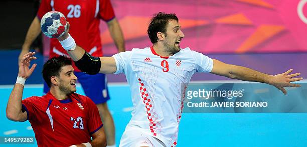 Croatia's pivot Igor Vori jumps to shoot next to Serbia's Nenad Vuckovic during the men's preliminaries Group B handball match Serbia vs Croatia for...