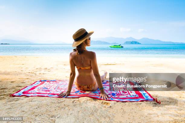 woman relaxing on tropical beach looking out - female looking away from camera serious thinking outside natural stock pictures, royalty-free photos & images