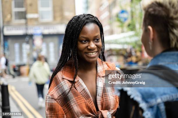 casually dressed young londoners outdoors and talking - girl rear view stock pictures, royalty-free photos & images