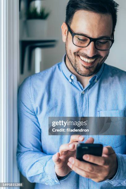 smiling businessman texting - good chat stockfoto's en -beelden