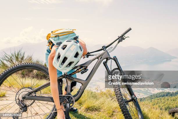woman fixing mountain bike on trail - flat tyre stock pictures, royalty-free photos & images