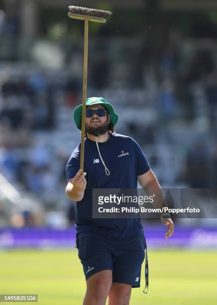 Harry Marshall of the MCC groundstaff leaves the field with a broom during the third day of the Test between England and Ireland at Lord's Cricket...