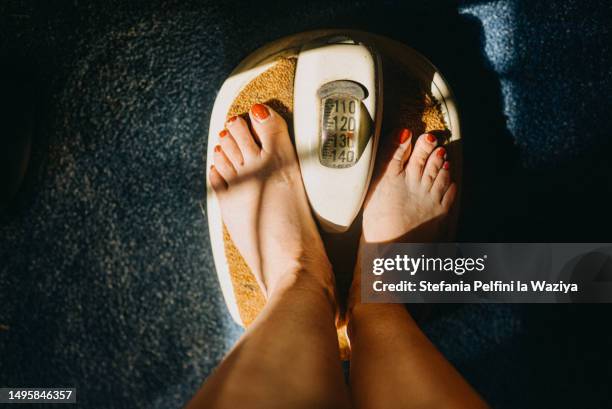 personal perspective of feet on scale - gewicht meeteenheid stockfoto's en -beelden