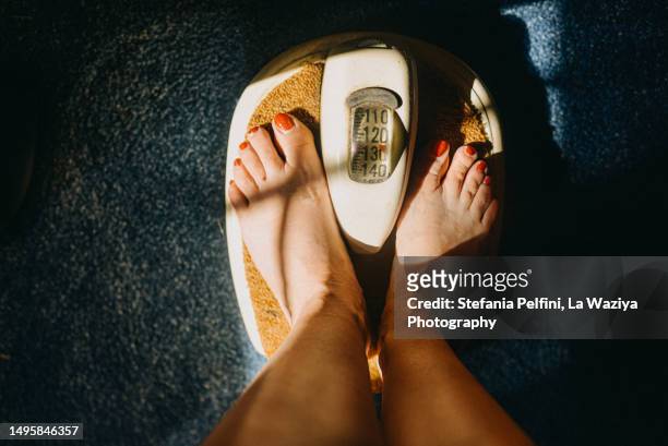 personal perspective of feet on scale - pound unit of mass 個照片及圖片檔