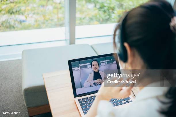 the asian businesswoman is using a laptop and a headset microphone for video calls, participating in remote meetings to discuss matters with colleagues or work partners. - matters stock pictures, royalty-free photos & images