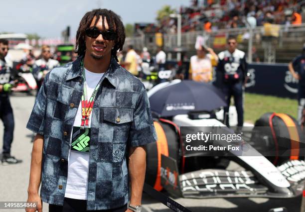 Trent Alexander-Arnold pose for a photo with the car of Yuki Tsunoda of Japan and Scuderia AlphaTauri on the grid prior to the F1 Grand Prix of Spain...