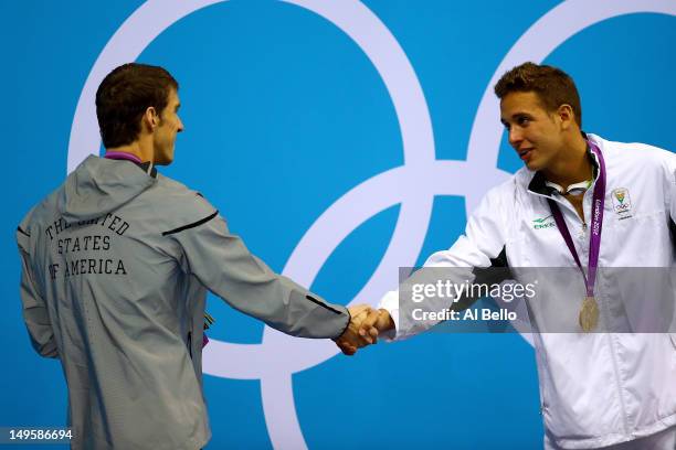 Silver medallist Michael Phelps of the United States shakes hands with gold medallist Chad le Clos of South Africa after receiving their medals...