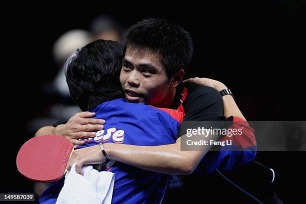 Chih-Yuan Chuang of Chinese Taipei celebrates winning with his coach during the Men's Singles Table Tennis quarter-final match against Adrian Crisan...