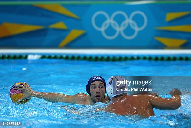 Rob Parker of Great Britain looks to pass around Zivko Gocic of Serbia during the Men's Water Polo preliminary round Group B match on Day 4 of the...