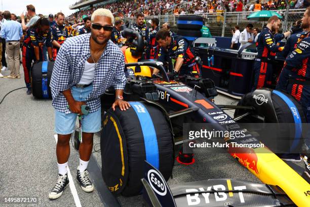 Serge Gnabry poses for a photo next to the car of Max Verstappen of the Netherlands and Oracle Red Bull Racing on the grid prior to the F1 Grand Prix...