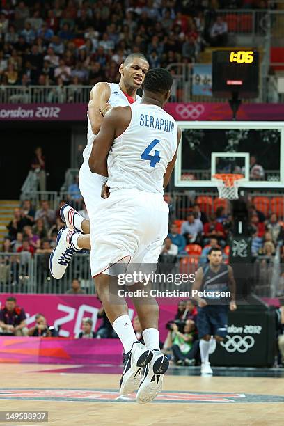 Nicolas Batum of France celebrates with team mate Kevin Seraphin after making a basket in the Men's Basketball Preliminary Round match between France...