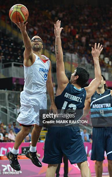 Argentinian centre Martin Leiva vies with French guard Tony Parker during the Men's preliminary round group A basketball match of the London 2012...