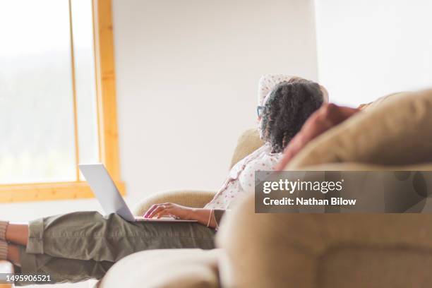 african-american woman works from her computer - woman in shower tattoo stock pictures, royalty-free photos & images