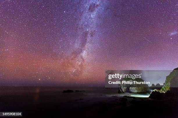 milky way galaxy at night with unique rock formation of a horse drinking water in foreground - meteorite stock pictures, royalty-free photos & images