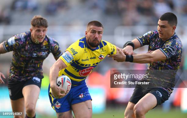 Warrington player Greg Minikin is tackled by Jake Clifford of Hull FC during the Betfred Super League Magic Weekend match between Hull FC and...
