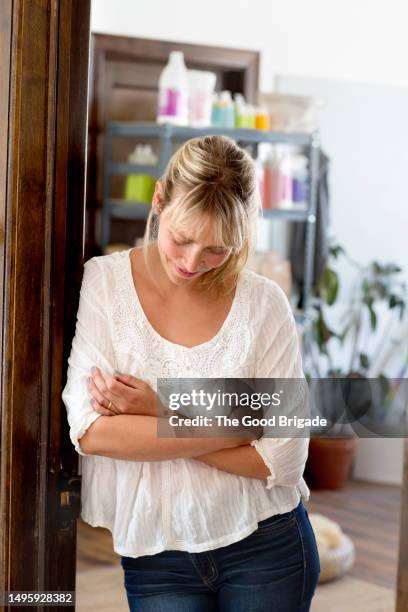 female business owner standing in doorway of office - tímido imagens e fotografias de stock