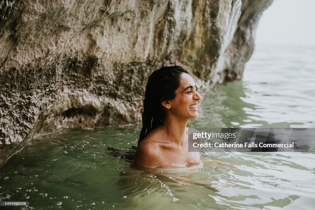 A woman skinny dips in the ocean