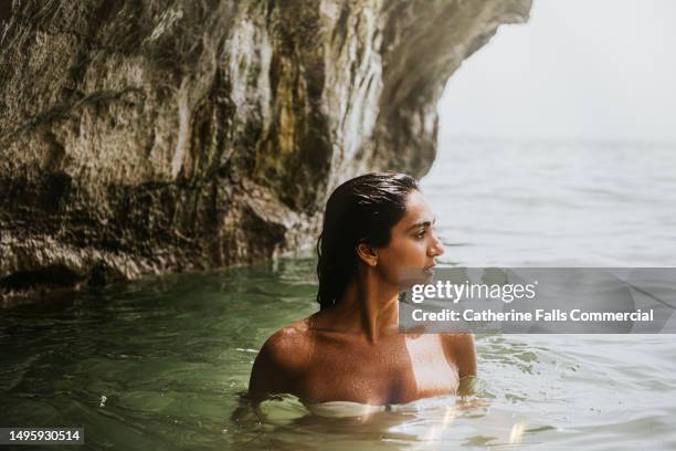 a woman enjoys a dip in the sea on a hot day - wet hair stock pictures, royalty-free photos & images