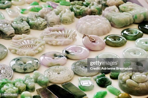 carved jade pendants on display - jade gemstone stockfoto's en -beelden