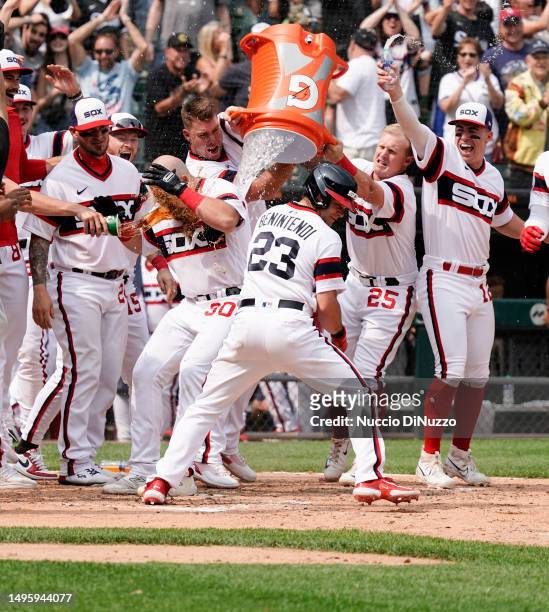 Jake Burger of the Chicago White Sox is mobbed by teammates following a walk off grand slam during the ninth inning of a game against the Detroit...