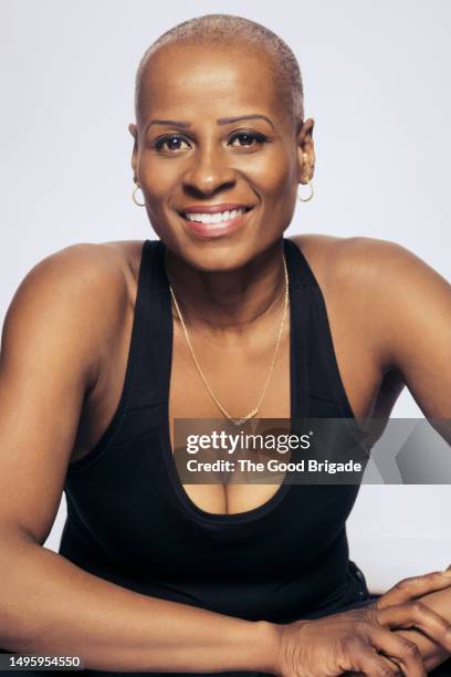 portrait of smiling mature woman with shaved head in studio - decolleté stockfoto's en -beelden
