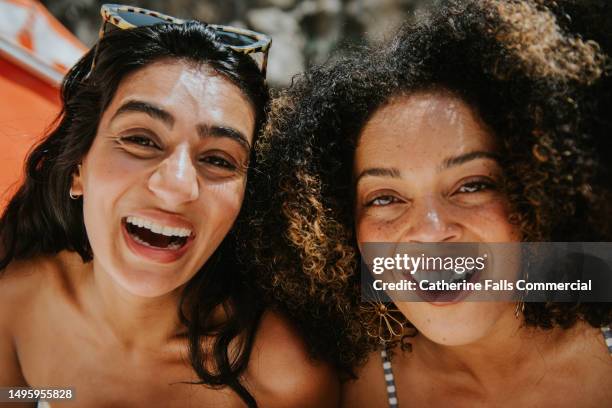 two happy woman look close into the camera and smile - smile asia woman stock-fotos und bilder