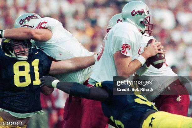 Washington Cougars Quarterback Ryan Leaf under pressure from Michigans James Steele during Rose Bowl game of Michigan Wolverines against Washington...