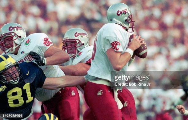 Washington Cougars Quarterback Ryan Leaf under pressure from Michigans James Steele during Rose Bowl game of Michigan Wolverines against Washington...