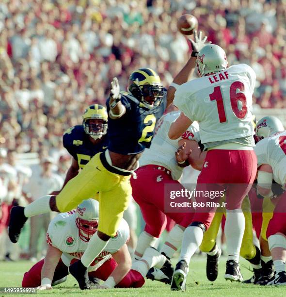 University of Michigan Wolverines Charles Woodson puts heavy pressure on Washington Quarterback Ryan Leaf during game action at Rose Bowl of Michigan...