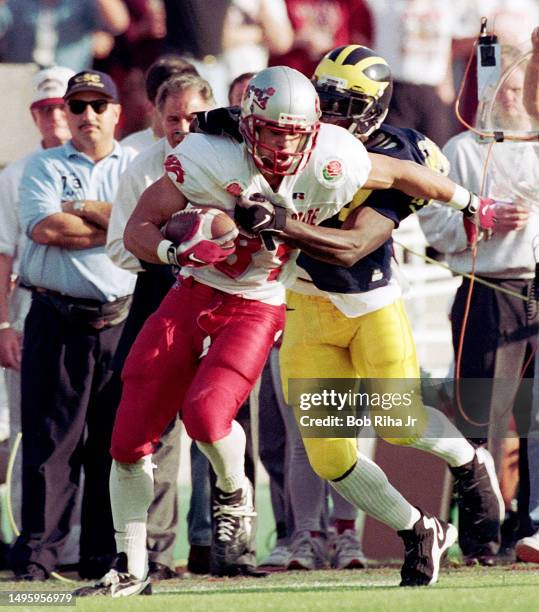 Washington State Wide Receiver Chris Jackson game action as Michigans Cornerback Tommy Hendricks moves in for tackle during Rose Bowl game of...