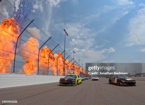 Pyrotechnics go off as Kyle Busch, driver of the 3CHI Chevrolet, and Ryan Blaney, driver of the Menards/Richmond Water Heaters Ford, lead the field...