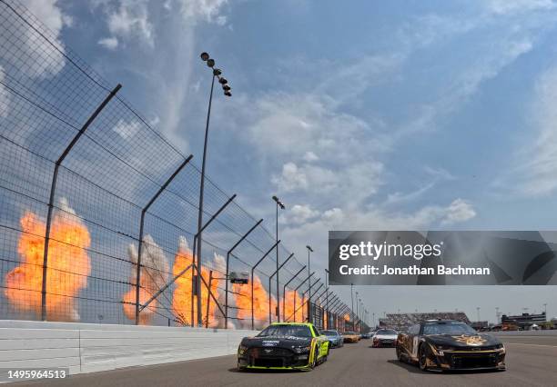 Pyrotechnics go off as Kyle Busch, driver of the 3CHI Chevrolet, and Ryan Blaney, driver of the Menards/Richmond Water Heaters Ford, lead the field...