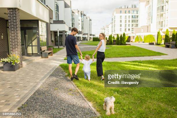 family with child in the yard. young woman, man and boy resting outdoors. summer background. modern city. lifestyle - family back yard stockfoto's en -beelden