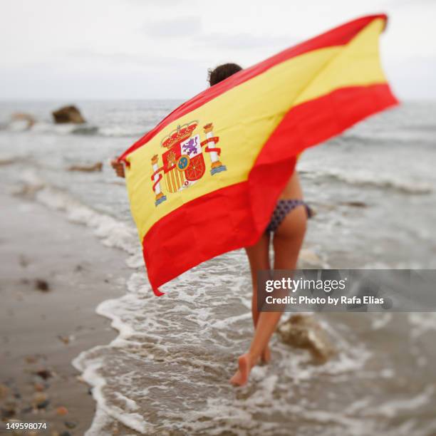 girl with spanish flag on beach - drapeau espagnol photos et images de collection