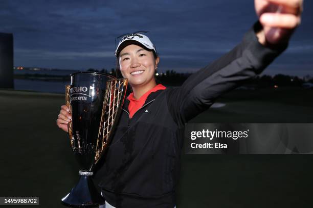 Rose Zhang of the United States imitates a “selfie” as she poses with the trophy after winning the Mizuho Americas Open in a playoff over Jennifer...