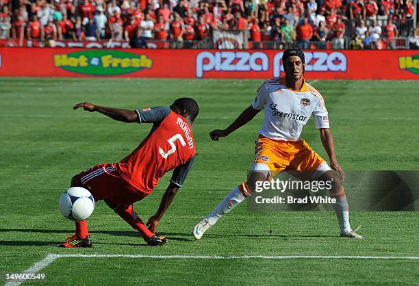 Ashtone Morgan of the Toronto FC battles for the ball with Calen Carr of the Houston Dynamo during MLS game action July 28, 2012 at BMO Field in...