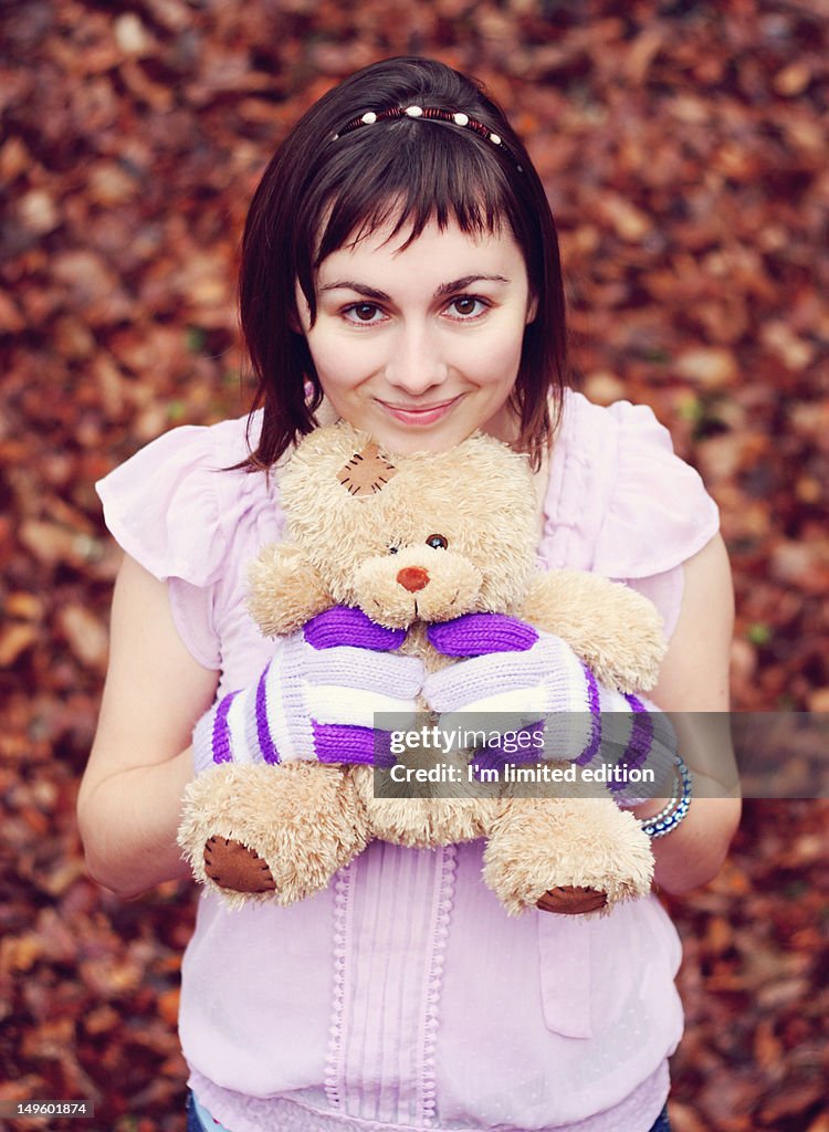 Young woman holding teddy bear